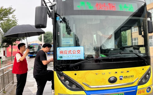 公交志愿者撑起爱心雨伞 “响应式公交”服务暖人心