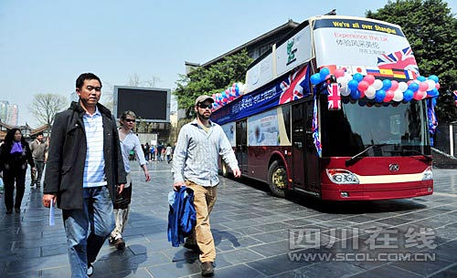 在宽窄巷子,几位外国游客从世博大巴旁经过