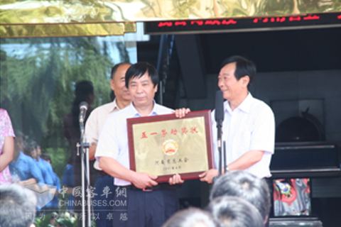 荥阳市人大常委会副主任、市总工会主席王海林向少林汽车党委副书记颁发河南省五一劳动奖状