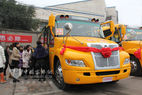  恒通工作人员为领导及参观的老师介绍安全校车及安全设施的使用