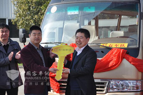 华山旅游汽车客运有限公司总经理刘新科（中间）接过江淮客车副总经理王泉龙金钥匙（右1）