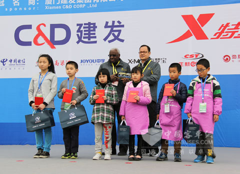 国际田联主席迪亚克和大金龙副总经理徐向东为获得“金龙客车 百米画卷”大赛一等奖小朋友颁奖