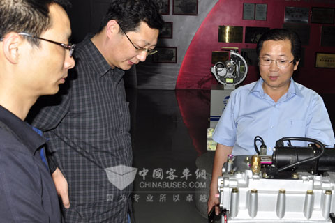 云珀在企业展厅向王江安董事长（中）介绍新能源客车变速器