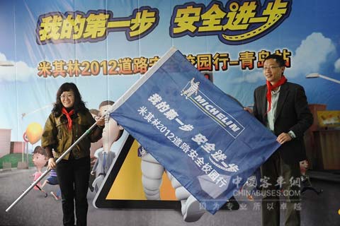 米其林（中国）品牌与传播部总监张震先生向青岛郑州路小学袁云校长授予旗帜