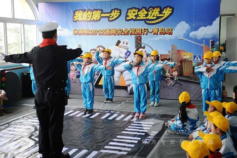 青岛郑州路小学的学生在交警的带领下表演交通安全手势操